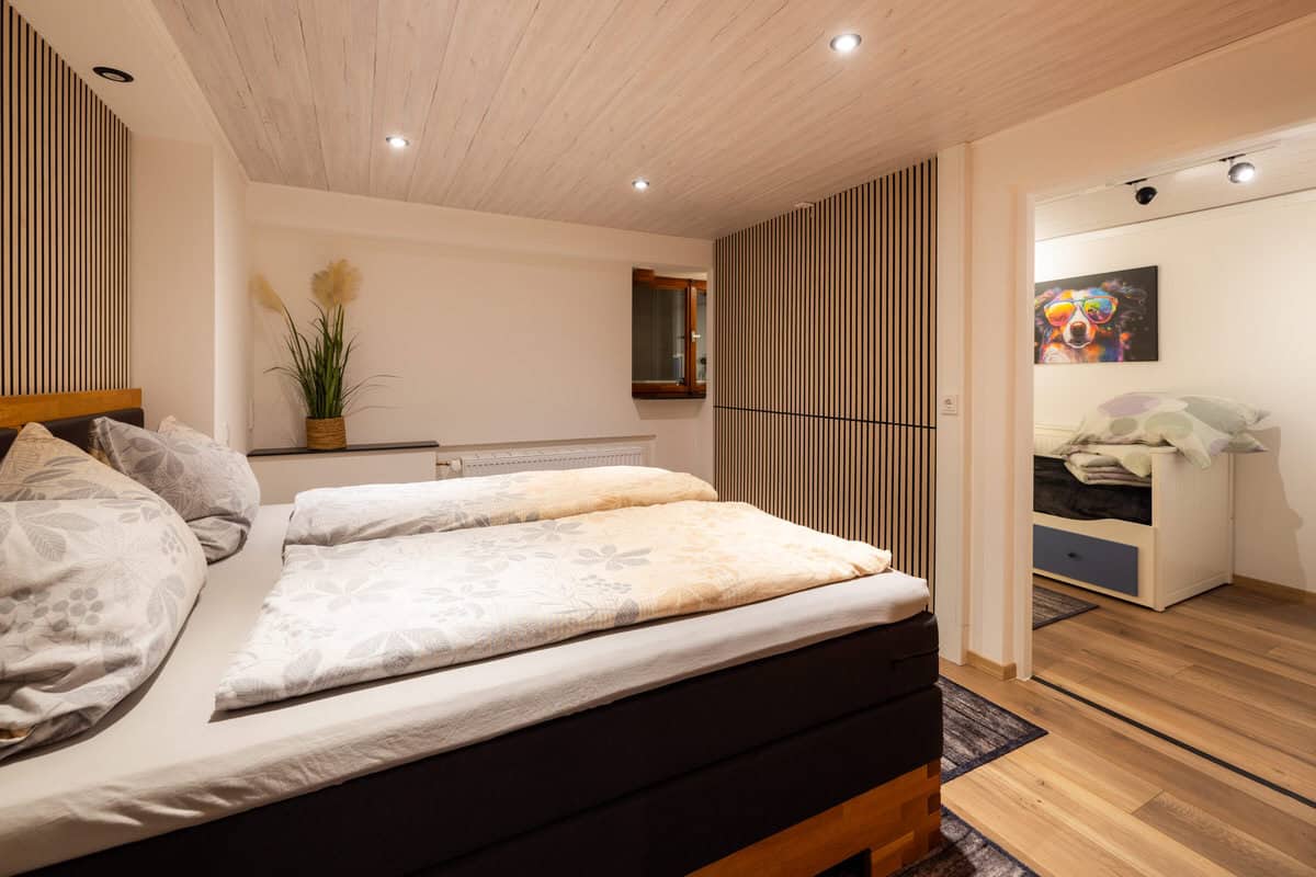 Gemütliches Ferienhaus Schlafzimmer mit modernem Holzdach und warmem Ambiente.