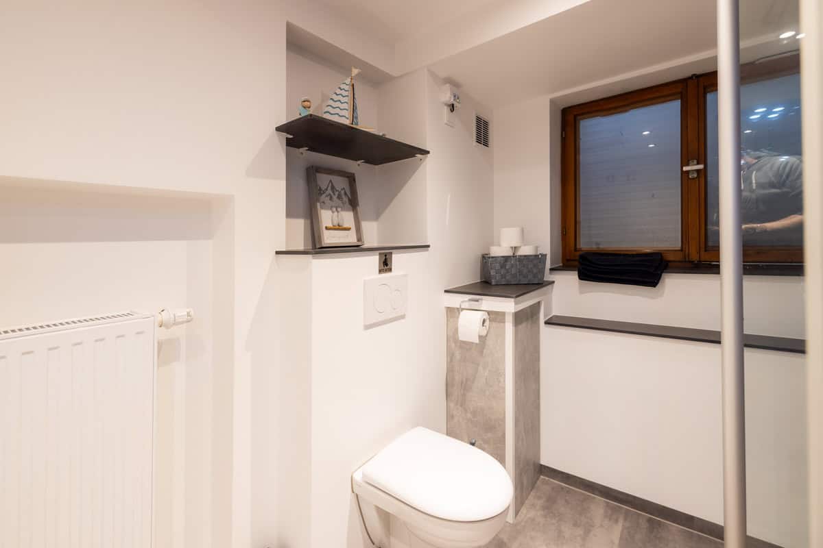 Modernes Ferienhaus Bad mit WC, Badmöbeln und Fenster in ruhiger Lage.