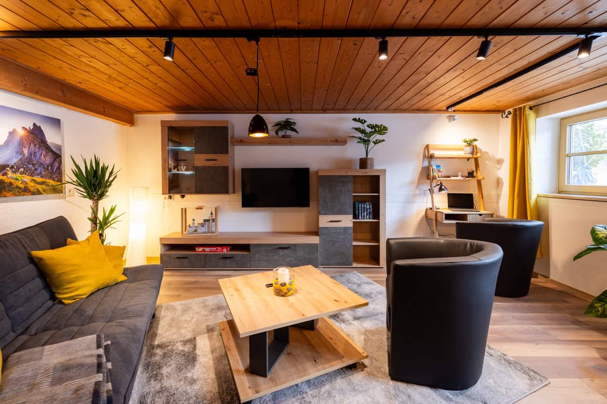Gemütliches Ferienhaus Karl Wohnzimmer mit moderner Einrichtung und Holzdecke, ideal für Familienferien.