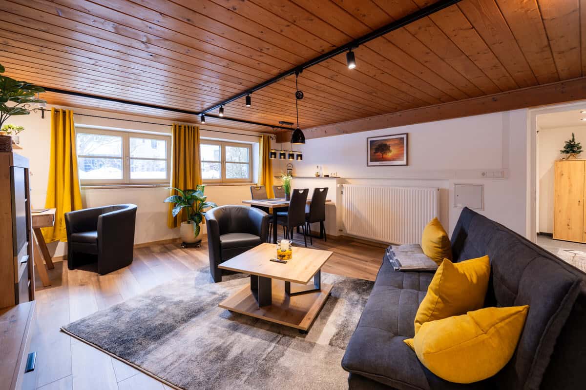 Gemütliches Ferienhaus Wohnzimmer mit Holzdecke, modernen Möbeln und viel Tageslicht in Karl.