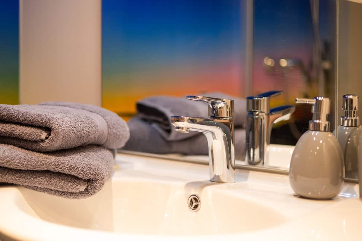 Sauberes Badezimmer mit Handtüchern und Seifenspender.