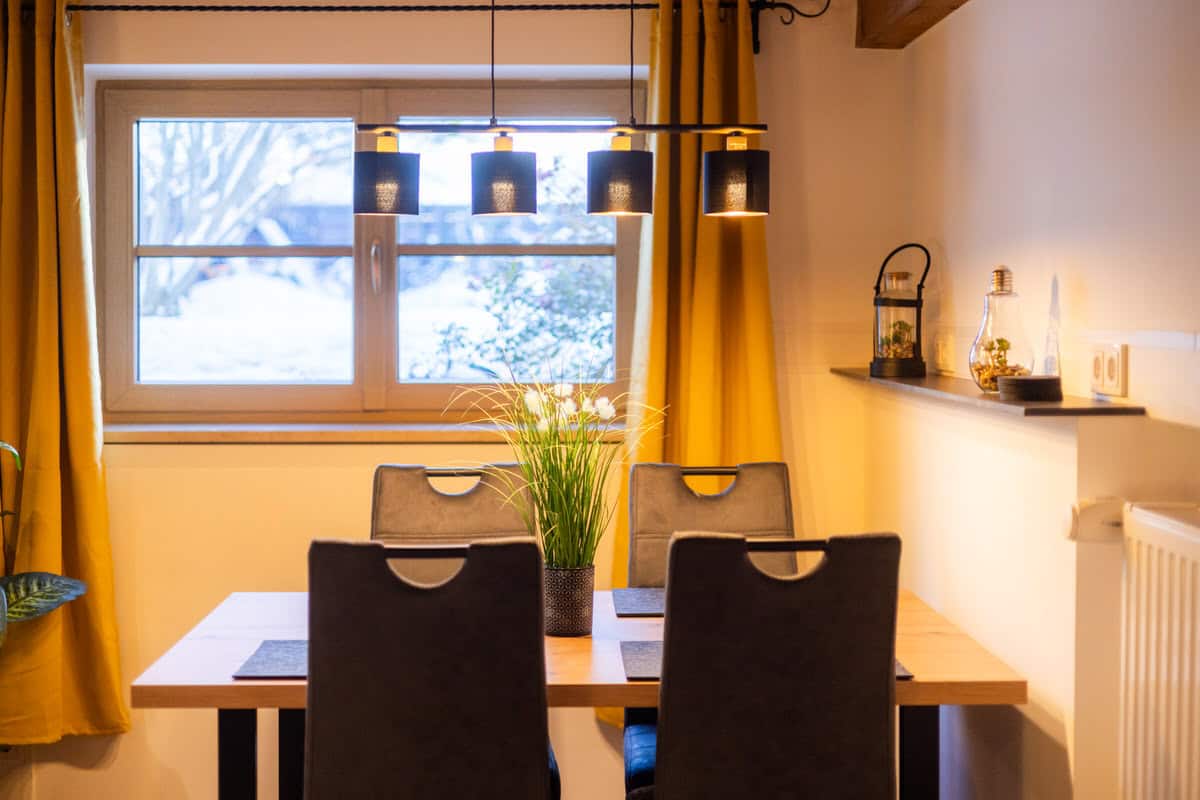 Gemütlicher Essbereich im Ferienhaus Karl mit moderner Beleuchtung und winterlichem Ausblick.