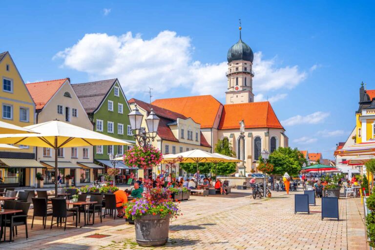 Bayerischer Marktplatz, buntes Stadtbild, historisches Rathaus, gemütliches Ambiente, beliebtes Reiseziel in Deutschland.